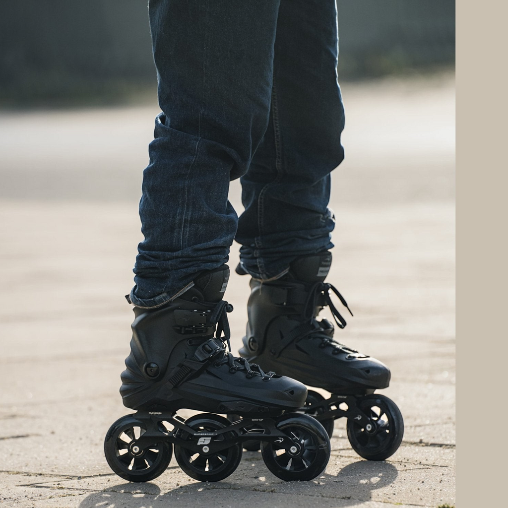 Patins KonRoller FlyingEagle Reaver Pro T110 pretos com base de três rodas de 110mm em uso urbano.