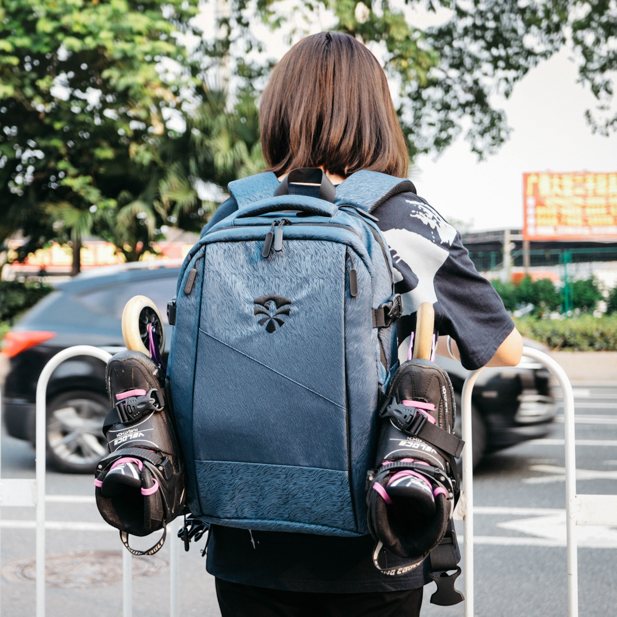 Mochila KonRoller FlyingEagle Movement cinza tamanho G com patins acoplados nas laterais em ambiente urbano