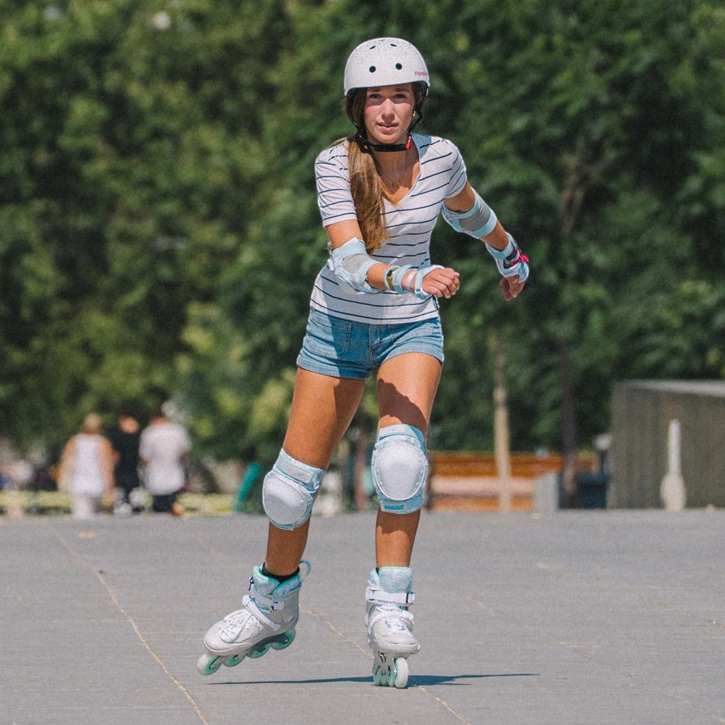 KonRoller patinadora usando capacete FlyingEagle Urban branco estrelado em ambiente urbano ao ar livre