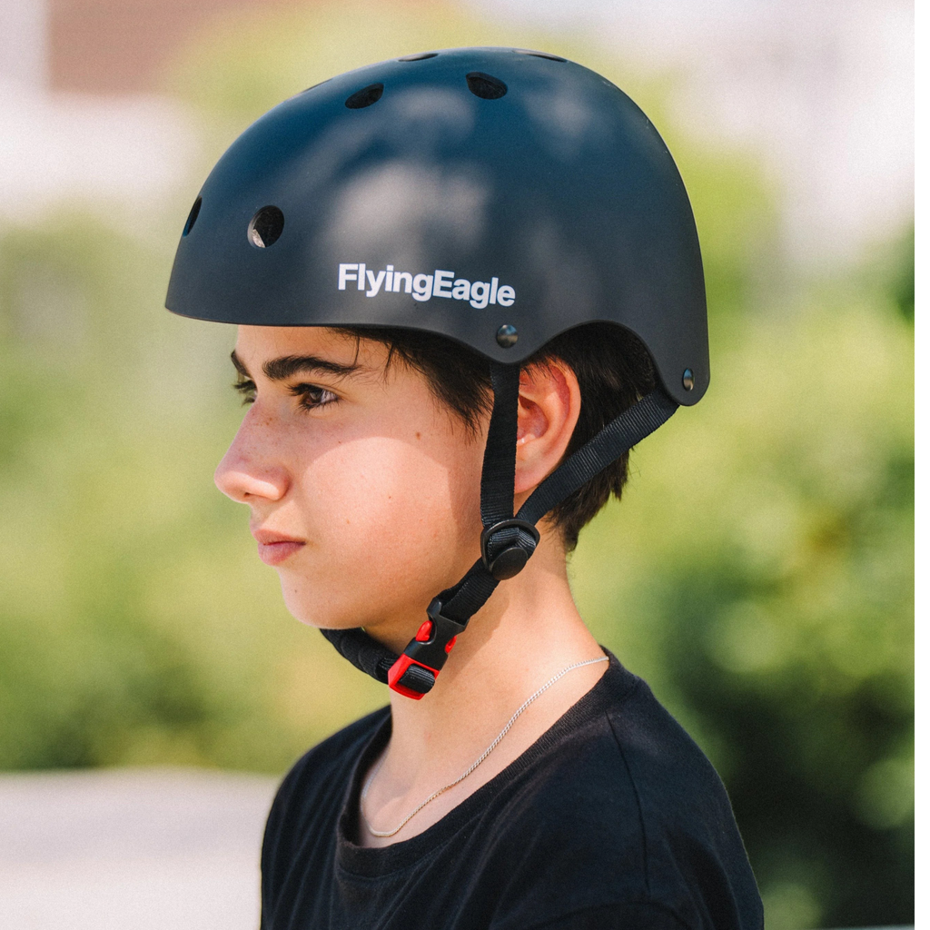 Jovem usando capacete preto fosco FlyingEagle Urban da KonRoller para patinação urbana e ciclismo em ambiente externo