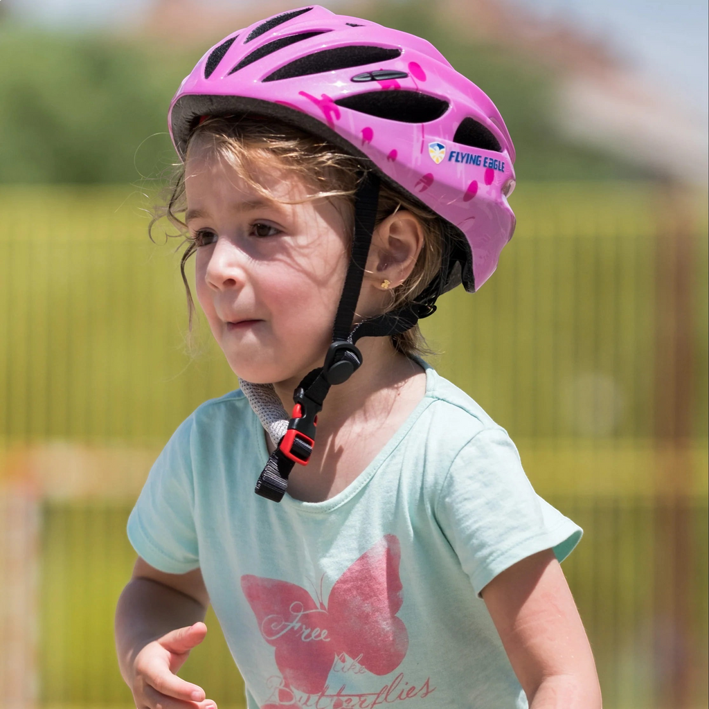 Menina usando capacete infantil rosa FlyingEagle Rapido JR da KonRoller para patins e bicicleta ao ar livre