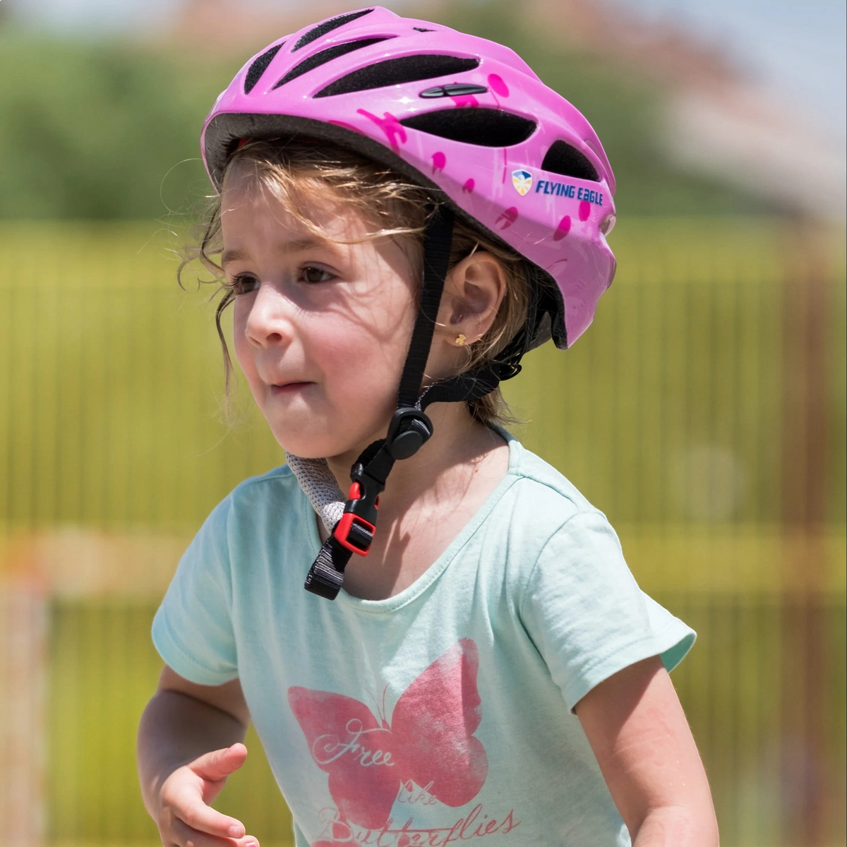 Menina usando capacete infantil rosa FlyingEagle Rapido JR da KonRoller para patins e bicicleta ao ar livre