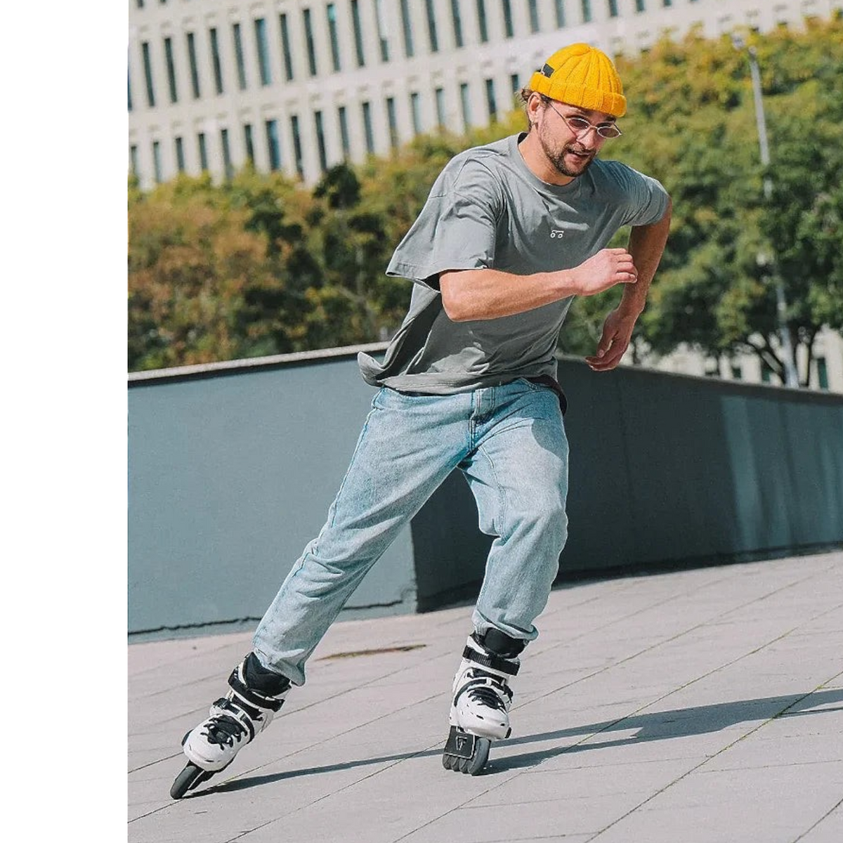 Homem patinando com patins KonRoller FlyingEagle Falcon Pro F6S brancos em ambiente urbano ao ar livre.